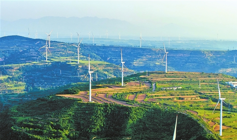 Wind turbines blend with green hills
